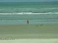 Frau mit Kindern spazieren am Strand